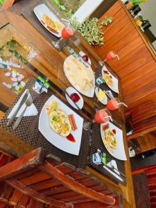 a wooden table with plates of food on it at Chill House safari resort in Udawalawe