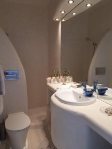 a bathroom with a sink and a toilet and a mirror at VILLA AGAPI KYTHNOS in Agios Dimitrios