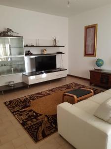 a living room with a white couch and a tv at La casa in più in Pesaro