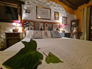 a bedroom with a large bed with two lamps on tables at Casa La Yedra by CasaTuristica in Benarrabá