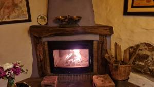 a fireplace in a living room with a fire in it at Casa La Yedra by CasaTuristica in Benarrabá