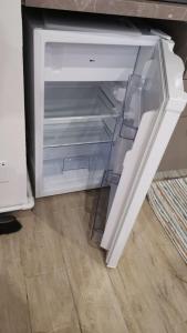 um frigorífico vazio com a porta aberta num quarto em La piccola bomboniera di Milano Nord em Milão