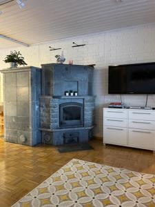 a living room with a fireplace and a flat screen tv at Tiitun Tupa Ivalo in Ivalo