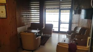 una sala de espera con sillas, una mesa y una ventana en YASİN OTEL, en Konya