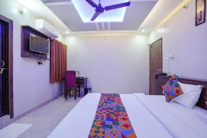een slaapkamer met een bed en een plafondventilator bij FabHotel Nandini Grand in Varanasi