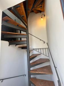 una scala a chiocciola in una camera con pareti bianche e soffitti in legno di Casa Nido Nilde a Siculiana