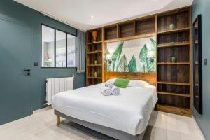 a bedroom with a bed and bookshelves at Hamac Suites - Suite du Parc 2 in Villeurbanne
