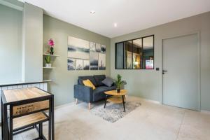 a living room with a blue couch and a table at Hamac Suites - Suite du Parc 2 in Villeurbanne