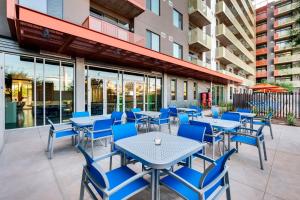 an outdoor patio with blue tables and chairs at Sophisticated City Living Apartments at Roosevelt Point, Phoenix in Phoenix