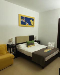 een kleine slaapkamer met een bed en een stoel bij Hotel Plebiscito Aparthotel in Napels