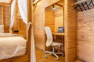 a bedroom with a desk and a bed and a chair at Emy Kerobokan in Kerobokan