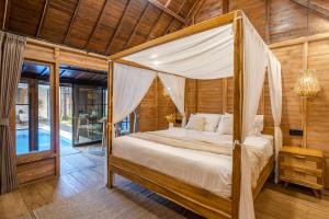 a bedroom with a canopy bed in a house at Emy Kerobokan in Kerobokan