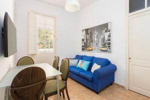 a living room with a blue couch and a table at Apartaments Clot-Sant Martí in Barcelona