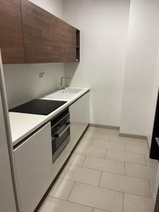 a white kitchen with a sink and a stove at Hotel Harmony Medical & Wellness-Free Parking, 1,8km from the center in Kroměříž