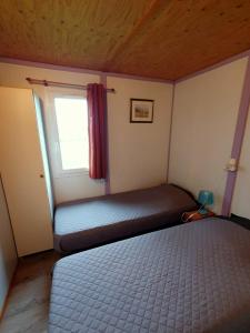 - une petite chambre avec un lit et une fenêtre dans l'établissement Les Chalets du Quignon, à Autry-le-Châtel