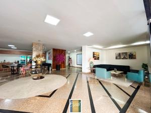 a large living room with blue chairs and tables at HOTEL OSCAR GOLD in Montes Claros