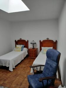 - une chambre avec deux lits et une chaise bleue dans l'établissement La Casa de Alicio en Moronta Salviva, 