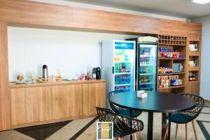 a dining room with a table and a refrigerator at HOTEL OSCAR GOLD in Montes Claros