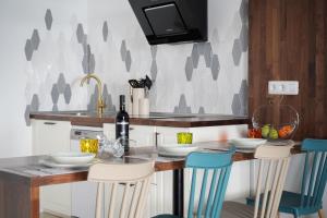 uma cozinha com uma mesa com cadeiras e um lavatório em Meraki em Playa Blanca