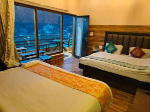 a hotel room with two beds and a balcony at Hotel Surya Lake view in Nainital