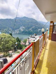 a balcony with a view of a river and mountains at Hotel Surya Lake view in Nainital