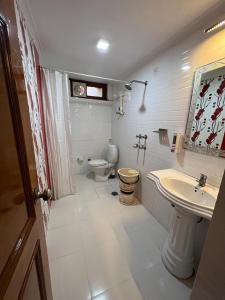 a bathroom with a toilet and a sink and a toilet istg at Hotel Surya Lake view in Nainital
