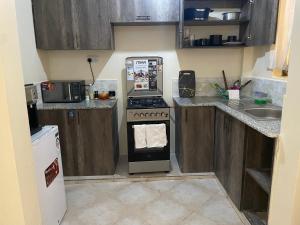 a small kitchen with a stove and a refrigerator at SNOWHAVEN BnB Kitengela in Kitengela 