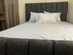a large bed with white sheets and pillows at SNOWHAVEN BnB Kitengela in Kitengela 