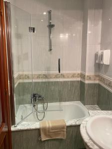 y baño con bañera y lavamanos. en Casa Goros II, en Melide