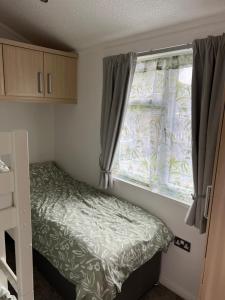 a small bedroom with a bed and a window at Throstles Nest in Troutbeck Bridge