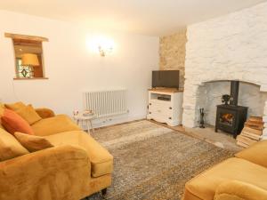 a living room with a couch and a fireplace at Norden Cottage in Weymouth