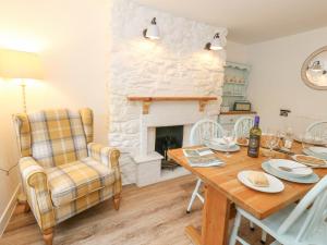 a dining room with a table and a fireplace at Norden Cottage in Weymouth