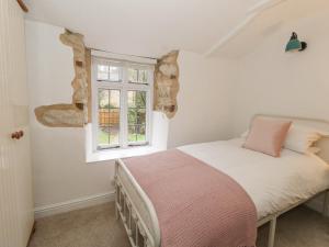 a bedroom with a bed and a window at Norden Cottage in Weymouth