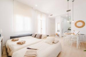 two beds in a white room with a desk at Casa San Miguel Terrace - Centro Zaragoza in Zaragoza