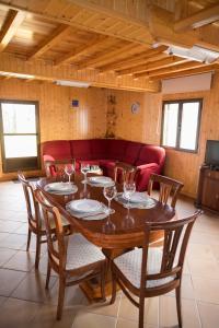 a dining room table with chairs and a red couch at CASA O PIÑEIRO in Redondela