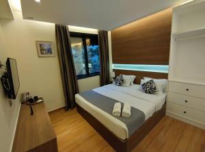 ein Schlafzimmer mit einem Bett mit zwei Schuhen drauf in der Unterkunft MS Hotel Kuala Lumpur in Kuala Lumpur