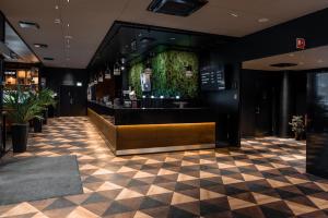 a lobby with a bar with a checkered floor at Original Sokos Hotel Puijonsarvi in Kuopio