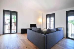 una sala de estar con sofá en una habitación con ventanas en Stunning apartment w amazing views and aircon, en Girona