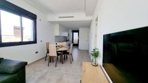 een woonkamer met een televisie en een eettafel bij Apartament Porto Marina in Torre de la Horadada