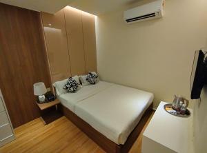 een kleine slaapkamer met een wit bed in een kamer bij MS Hotel Kuala Lumpur in Kuala Lumpur