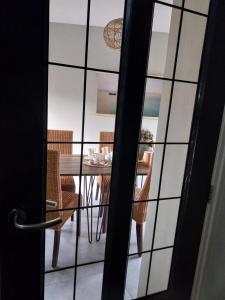 een uitzicht op een eettafel met stoelen door een deur bij B&B Moria in Surhuisterveen +13 foto's