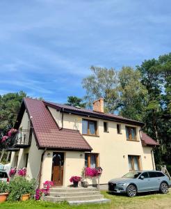 a house with a car parked in front of it at Diuna in Dębki