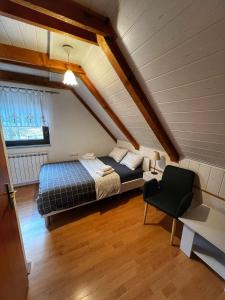 a bedroom with a bed and a chair in a attic at Villa Lykos Plitvice in Plitvička Jezera