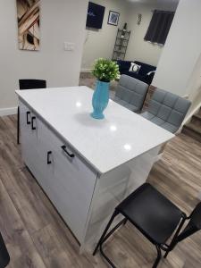 a white counter with a vase with flowers on it at Family-Friendly, NETFLIX, Cozy Comfy 2 bed room basement suite,sleeps 5 in Edmonton