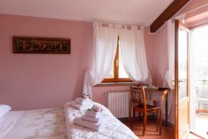 een slaapkamer met een bed, een bureau en een raam bij Rosso Del Chianti in Panzano
