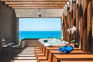 a bathroom with a tub and a view of the ocean at Sheraton Rhodes Resort in Ixia