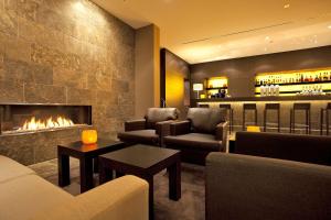 a living room with couches and a fireplace at ATLANTIC Hotel Lübeck in Lübeck