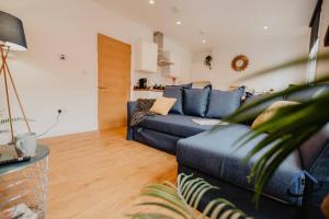 a living room with a blue couch at Contemporary flat, sleeps 4, very central, parking in Northampton