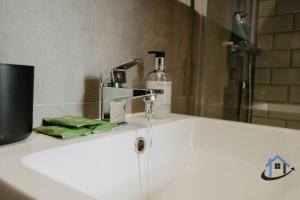a bathroom with a sink with a faucet at Contemporary flat, sleeps 4, very central, parking in Northampton