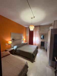 a hotel room with two beds and a television at Hotel L'Approdo in Brindisi